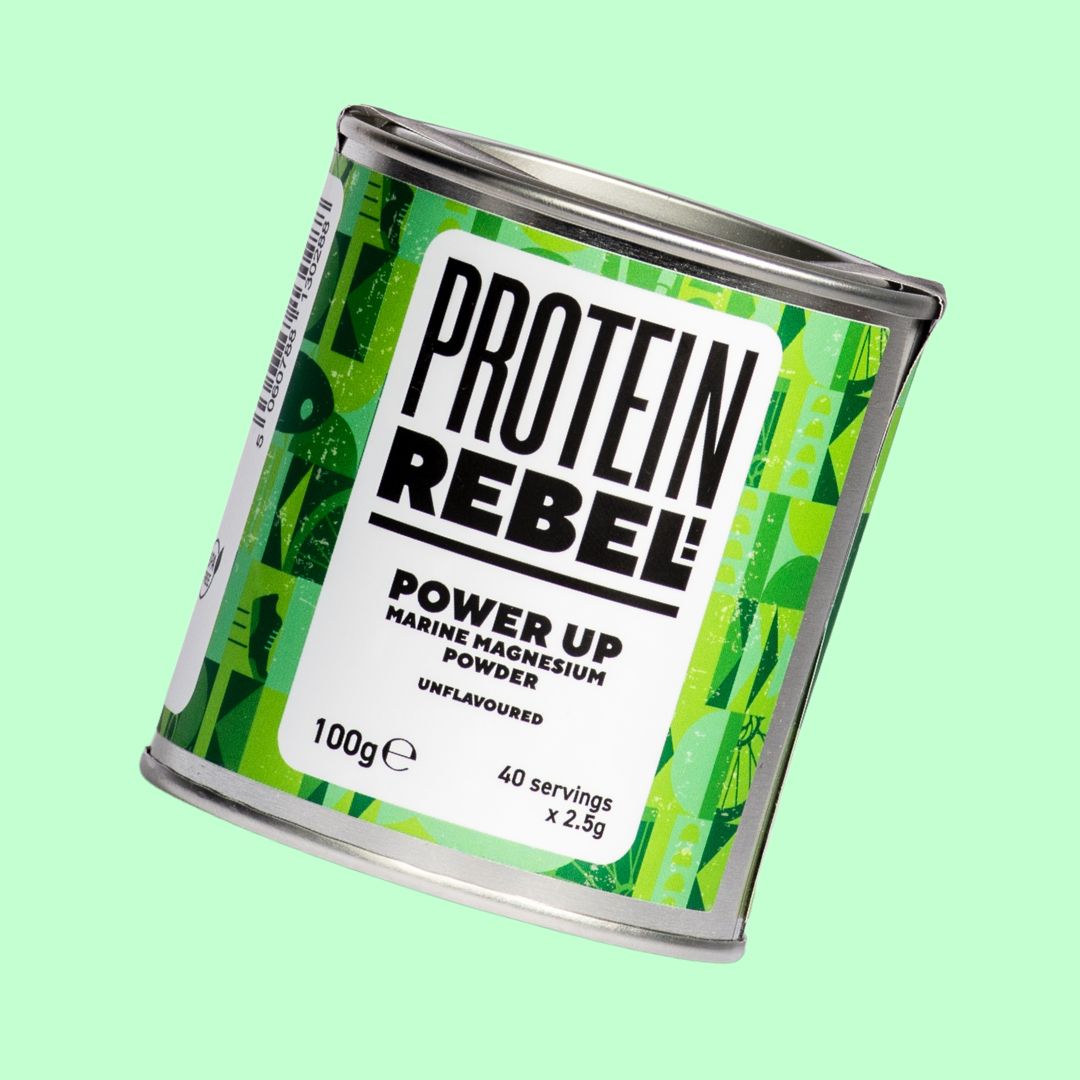 Protein Rebel power up powder tin on a light green background